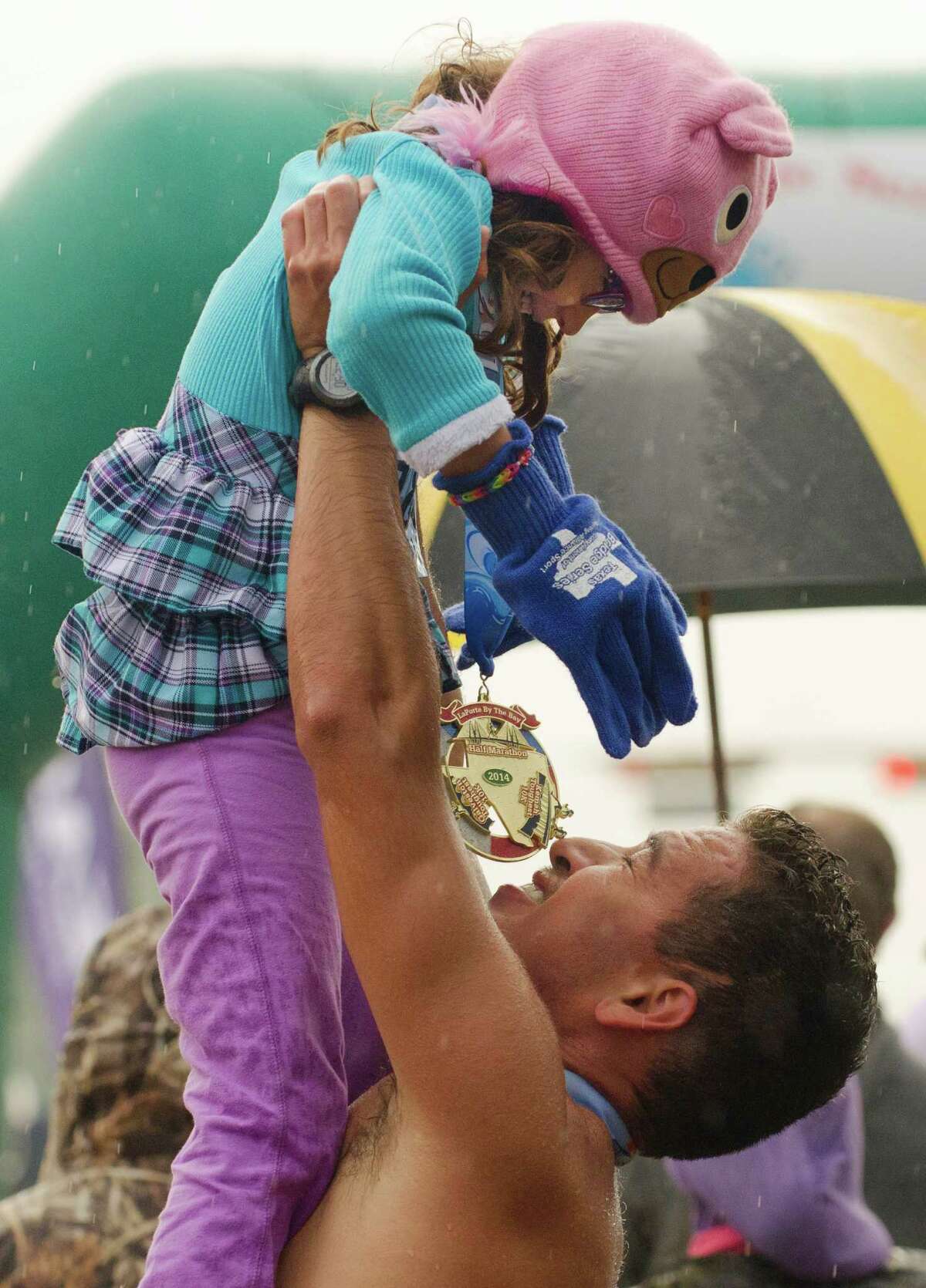 Iram Leon lifts up his daughter Kiana, 7, in celebration after finishing the La Porte by the Bay Half Marathon in 1 hour, 25 minutes on Sunday.﻿﻿﻿