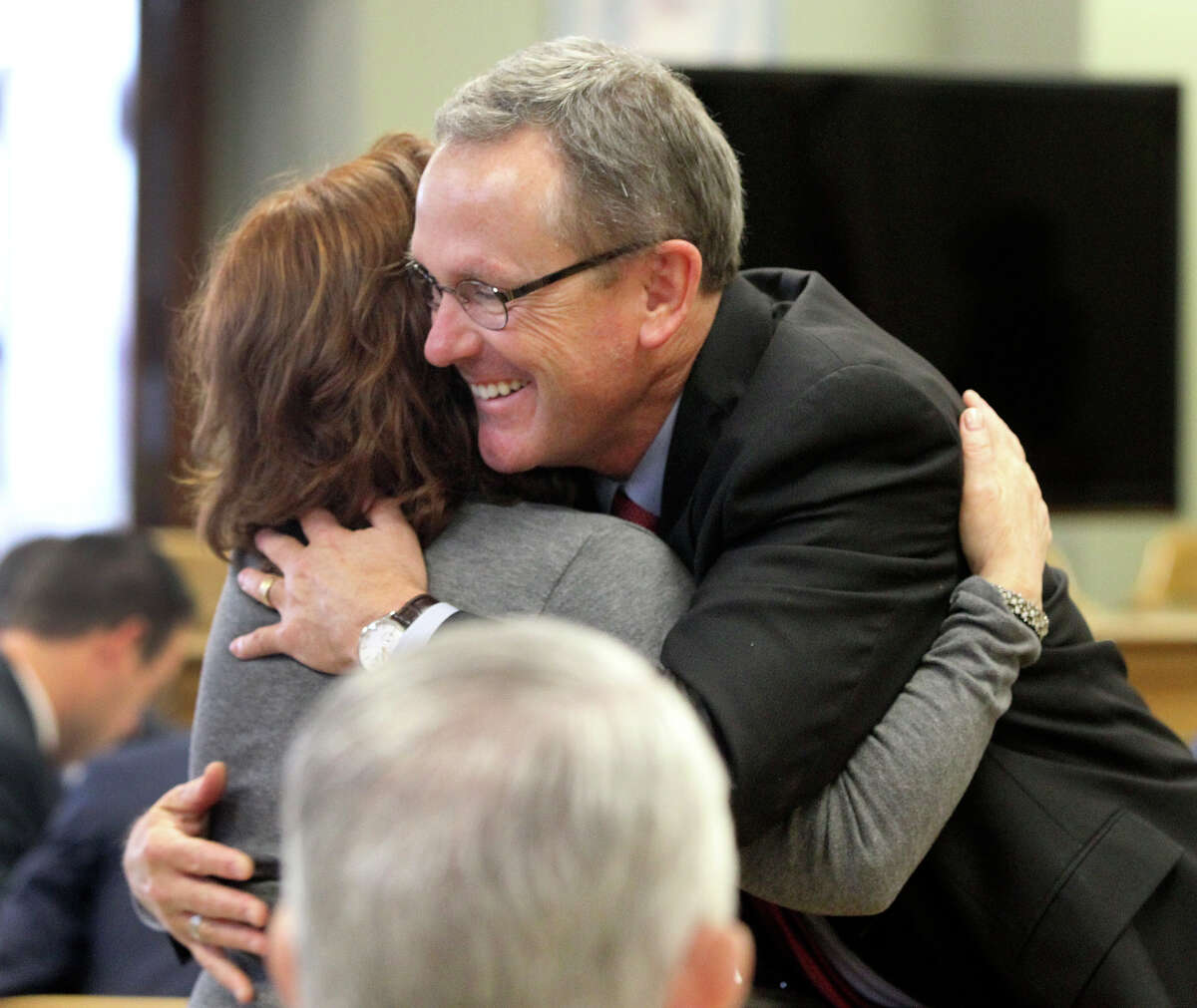 Attorney Mike McCrum (right) gets a hug from a supporter Monday November 17, 2014 in the 225th District Court at the Bexar County Courthouse during a contempt of court hearing. McCrum, serving as a special prosecutor in the case against Gov. Rick Perry, who is also accused of professional misconduct, could spend up to six months in jail if found guilty in contempt. After nearly a nine-month hiatus, the hearing resumed for McCrum.