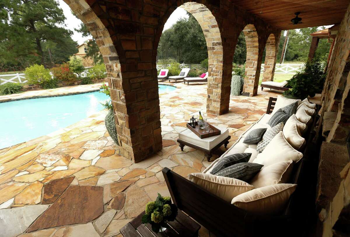 The stone arches of the loggia frame views of the pool, garden and barn in the distance. ( Karen Warren / Houston Chronicle )