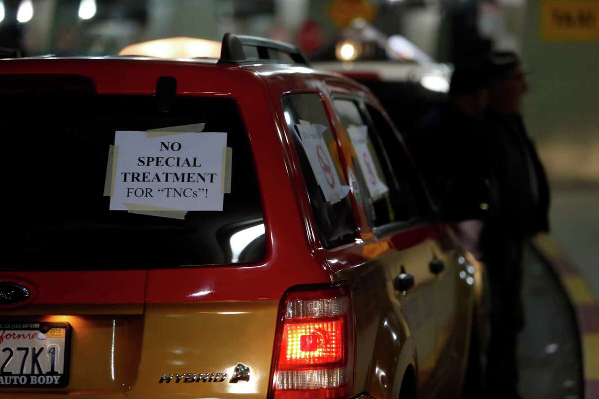 Taxi drivers stand outside Terminal 3 during a protest at San Francisco International Airport on Nov. 17, 2014.