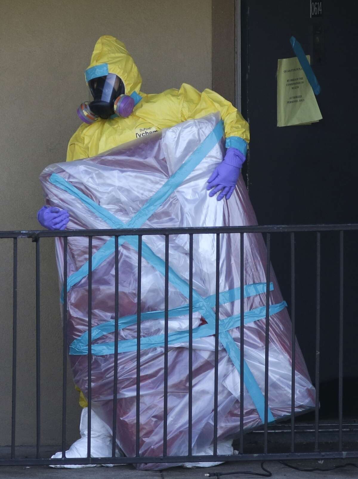 A hazardous material cleaner removes an item from a Dallas apartment where Duncan stayed.