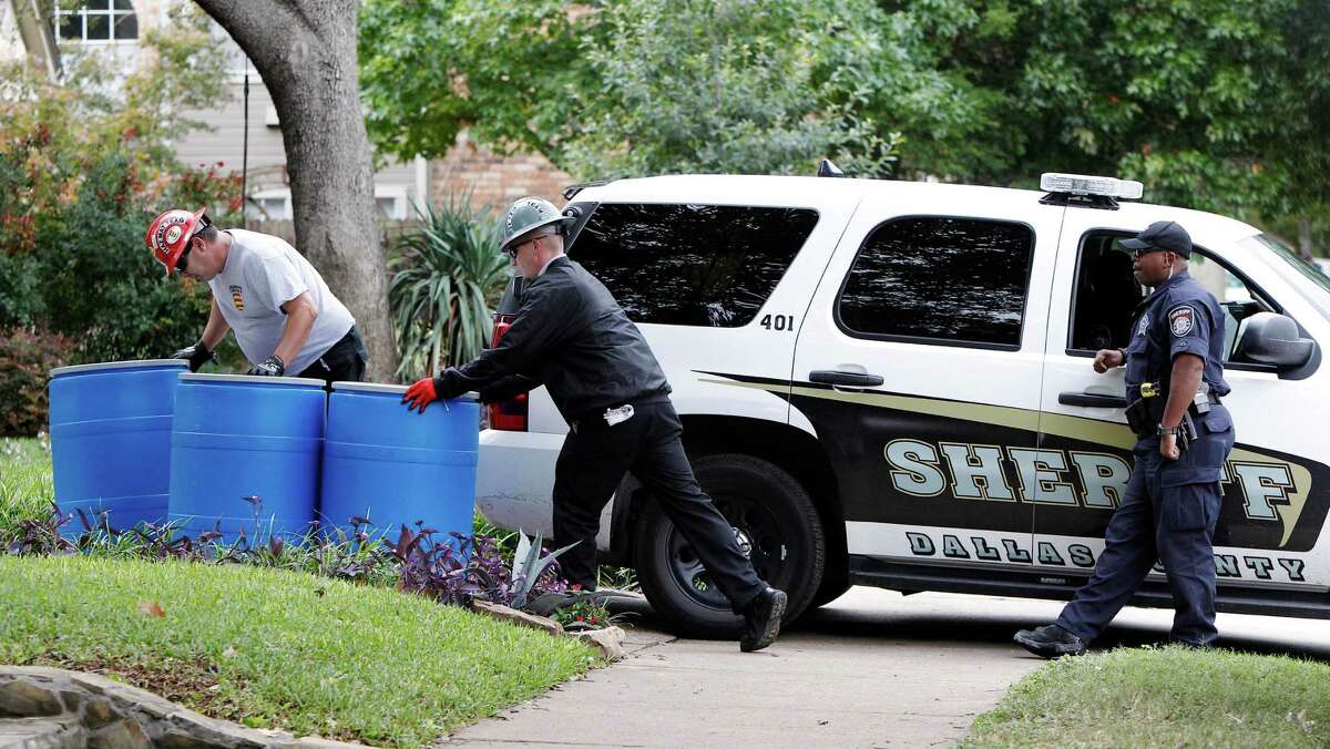 Protect Environmental workers move disposal barrels to a staging area outside the apartment of a healthcare worker who treated Ebola patient Thomas Eric Duncan and tested positive for the disease.