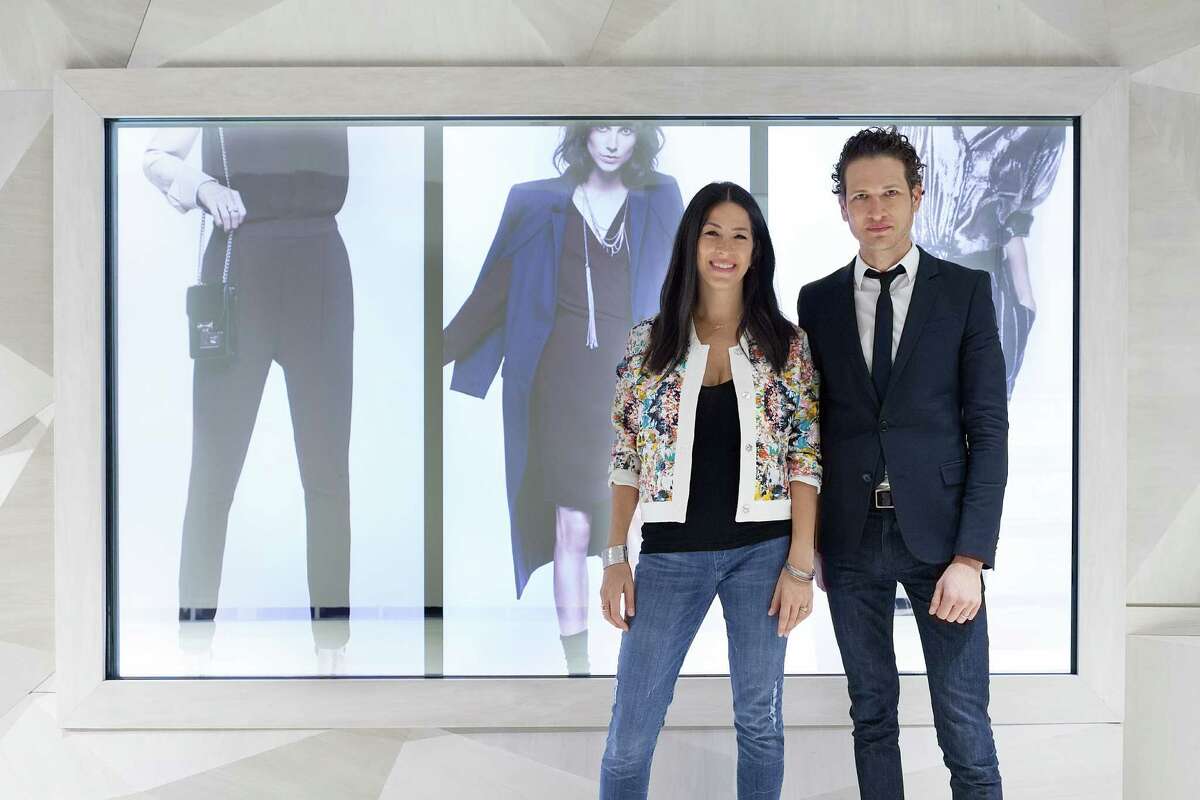 Designer Rebecca Minkoff with company CEO, Uri Minkoff, in front of the three screens that make up the store’s connected wall.