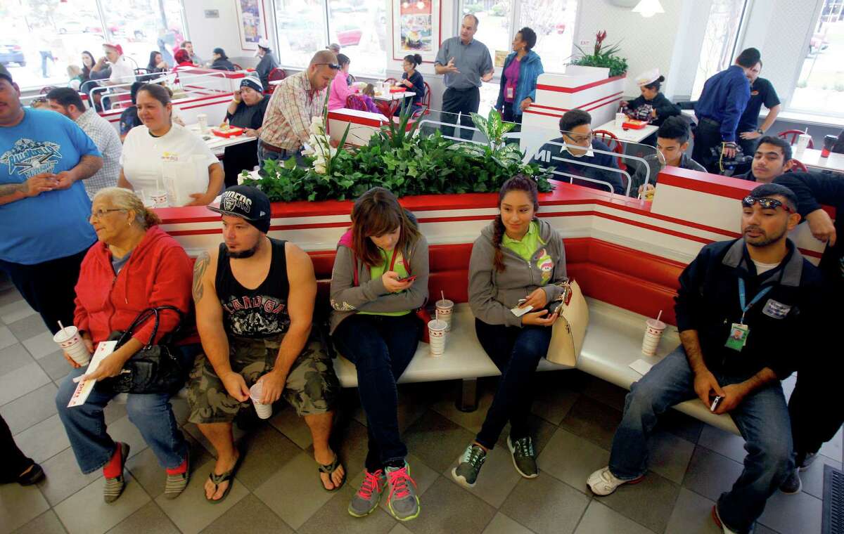 People wait for their order number to e called while they attend the grand opening Thursday Nov. 20, 2014 of San Antonio's first In-N-Out Burger. The store, located on Culebra just outside Loop 1604, opened at 9 a.m. because of the large crowds of people already in line for the store's normal 10 a.m. opening.
