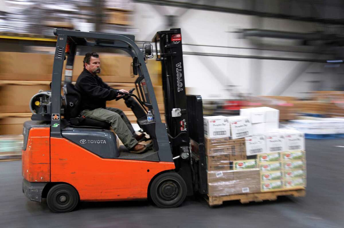 Al White moves a pallet of food through the warehouse of the SF-Marin Food Bank in San Francisco.
