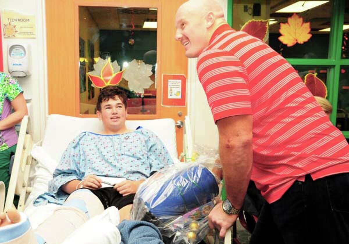 Houston Texans center Chris Myers chats with Children’s Memorial Hermann Hospital pediatric patient 13-year-old Harrison Fason before giving him a “Basket of Hope” and signing the football fan’s cast.