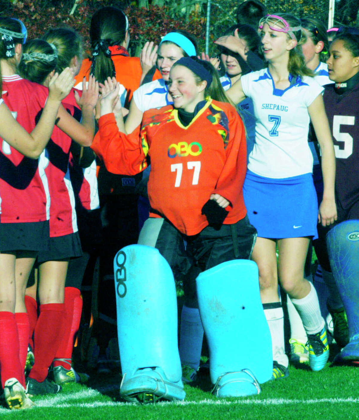 Spartan goaltender Rachel Genua, Kelsey Johnson and Kaitlyn Smith (7) lead their teammates exchanging respects with the Highlanders following Shepaug Valley School field hockey's state class 'S' tournament 3-1 victory over Northwestern in Washington, Nov. 3, 2014