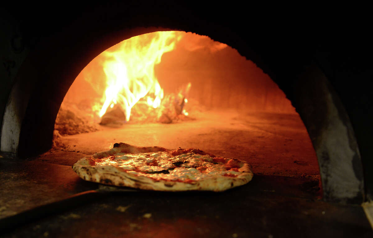 A fresh pizza is taken out of a 1000 degree oven at Brick + Wood Pizza in this Nov. 2014 file photo