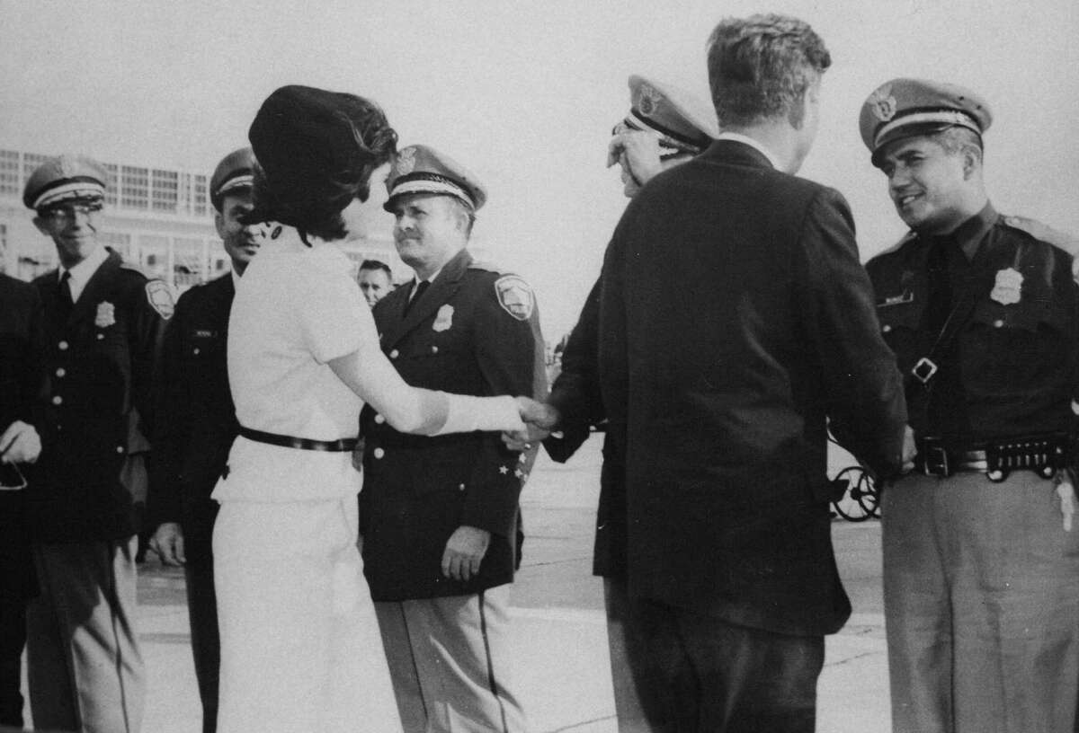 The Kennedys are greeted by police officials at San Antonio International Airport.