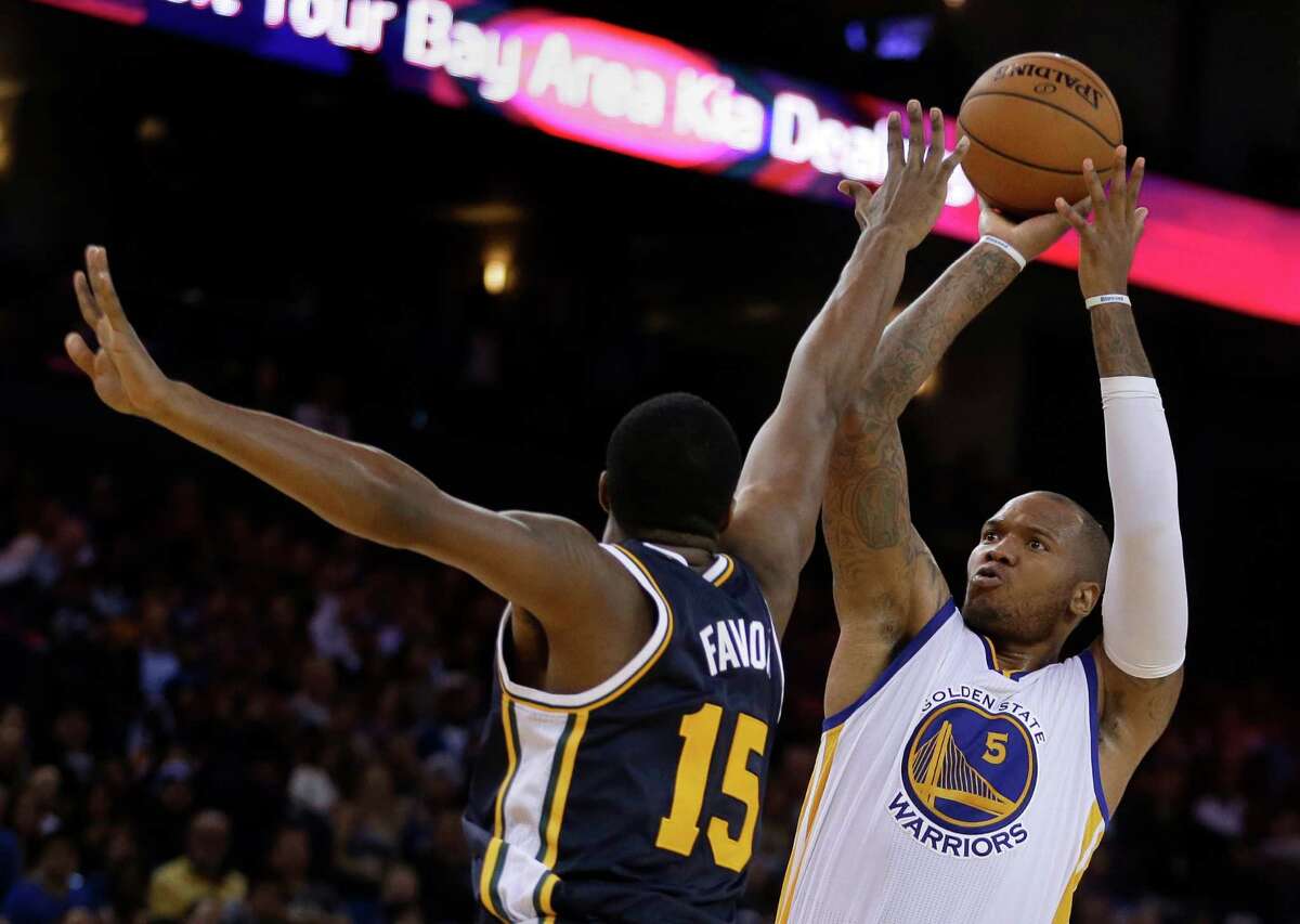 Golden State Warriors' Marreese Speights shoots against Utah Jazz forward Derrick Favors during the second half of an NBA basketball game Friday, Nov. 21, 2014, in Oakland, Calif. (AP Photo/Ben Margot)