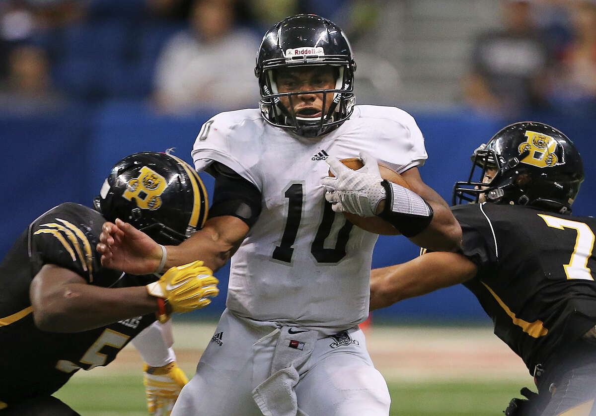 Knight quarterback LG Williams wedges his way between Dj Allen (left) and Devontre McGarity as Steele plays Brennan at the Alamodome in second round 6A high school Division I I playoff action on November 22, 2014.