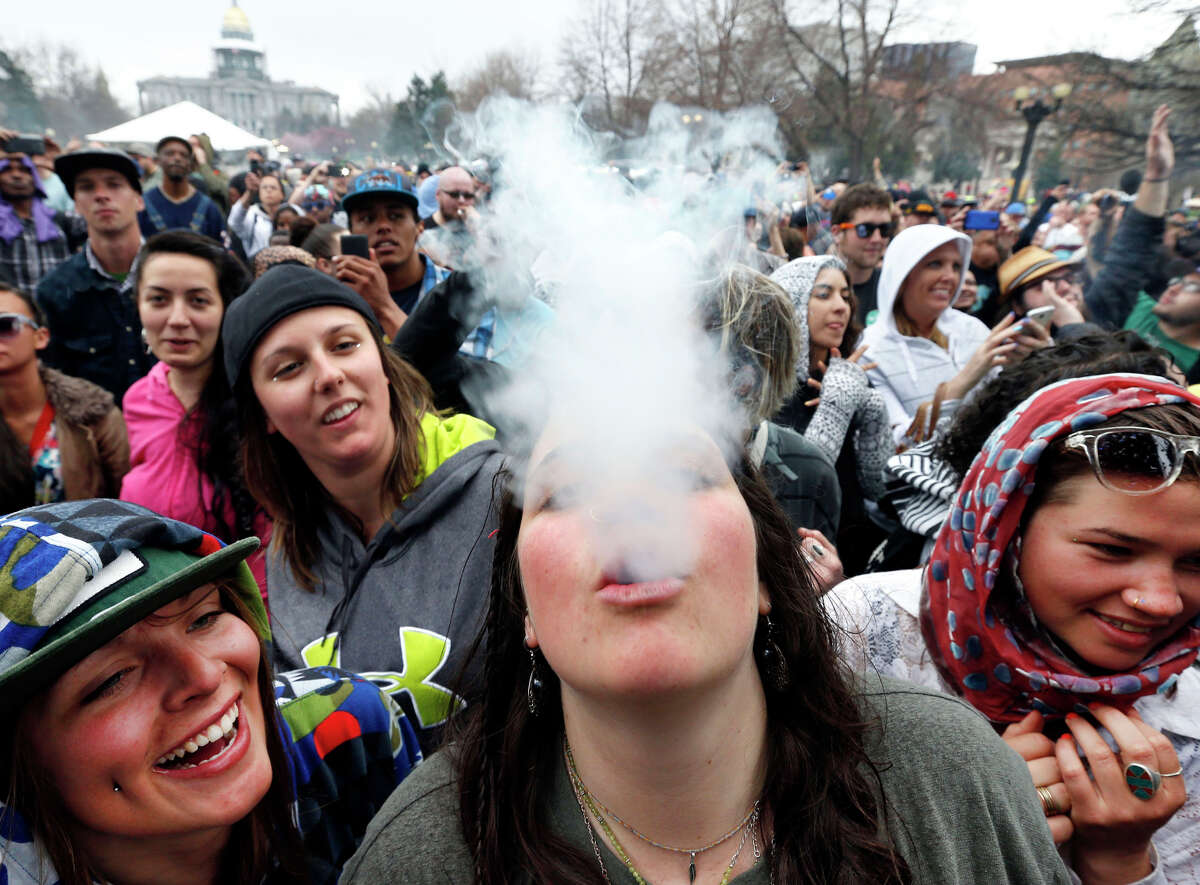 Partygoers dance and smoke pot April 19, the first of two days of the annual 4/20 marijuana festival in Denver. The 4/20 event was the first one since Colorado legalized recreational marijuana in January.