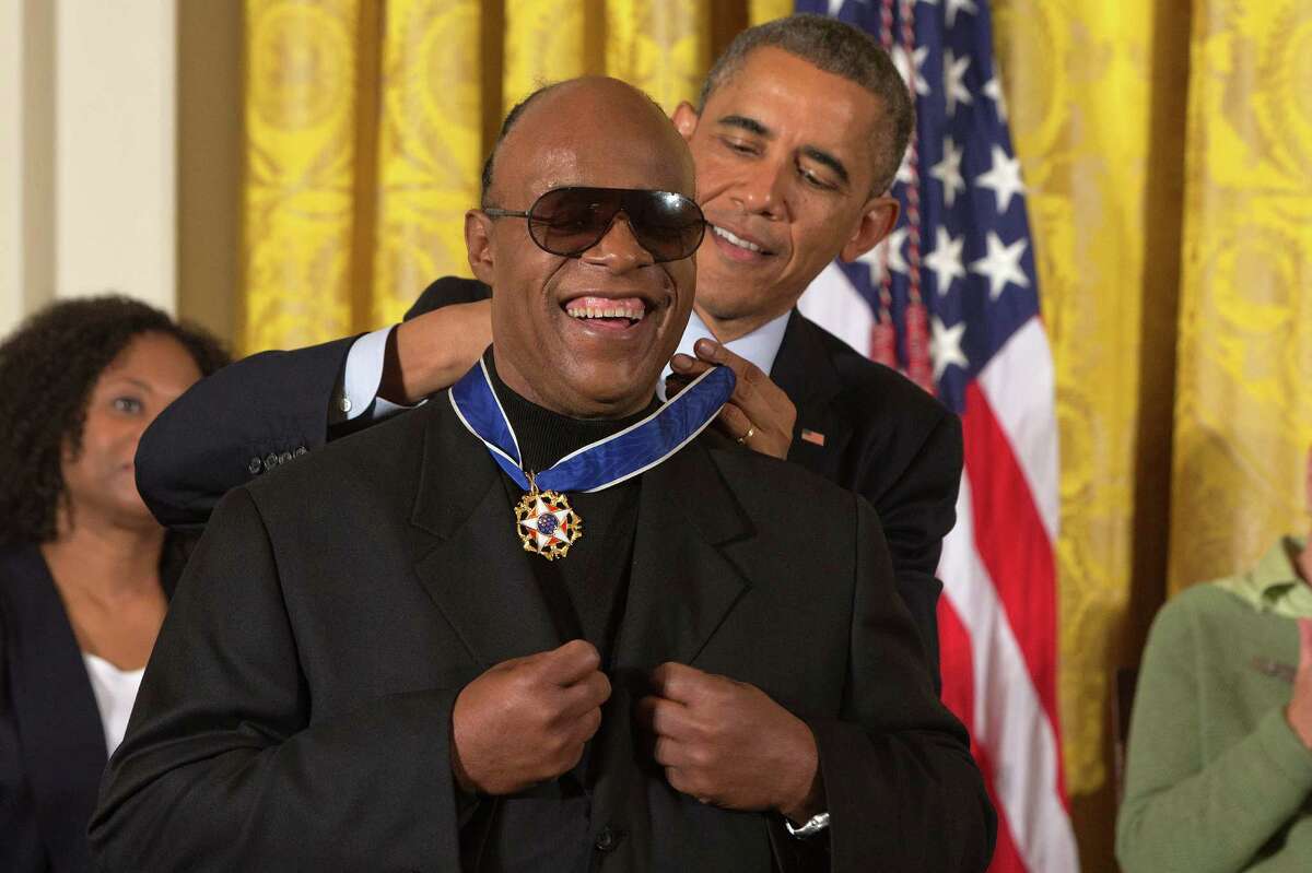Musician Stevie Wonder celebrates as President Barack Obama awards him the Presidential Medal of Freedom, Monday, Nov. 24, 2014, during a ceremony in the East Room of the White House in Washington. President Obama is presenting the nation's highest civilian honor to 19 artists, activists, public servants and others. (AP Photo/Jacquelyn Martin)