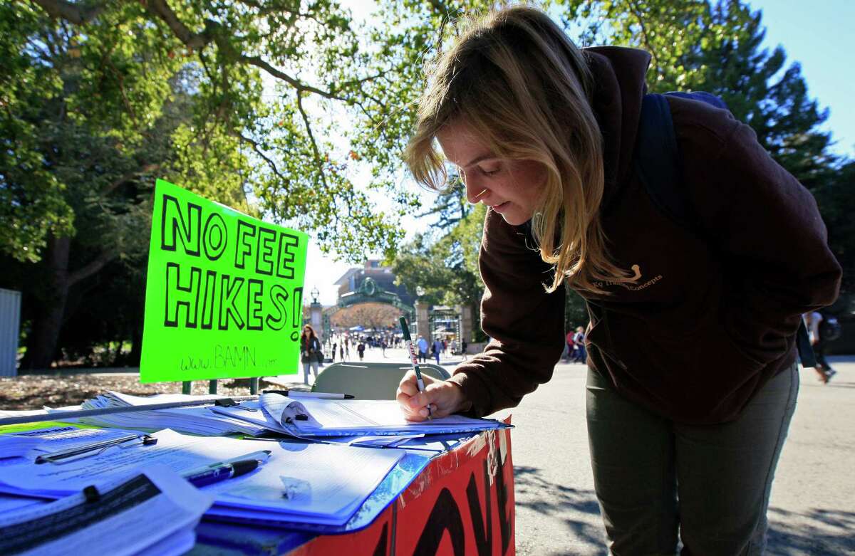 UC Berkeley student Allie Lalor signs a petition before joining in a walk-out of classes, protesting a recent approval of UC tuition hikes, on Nov. 24 at UC Berkeley.