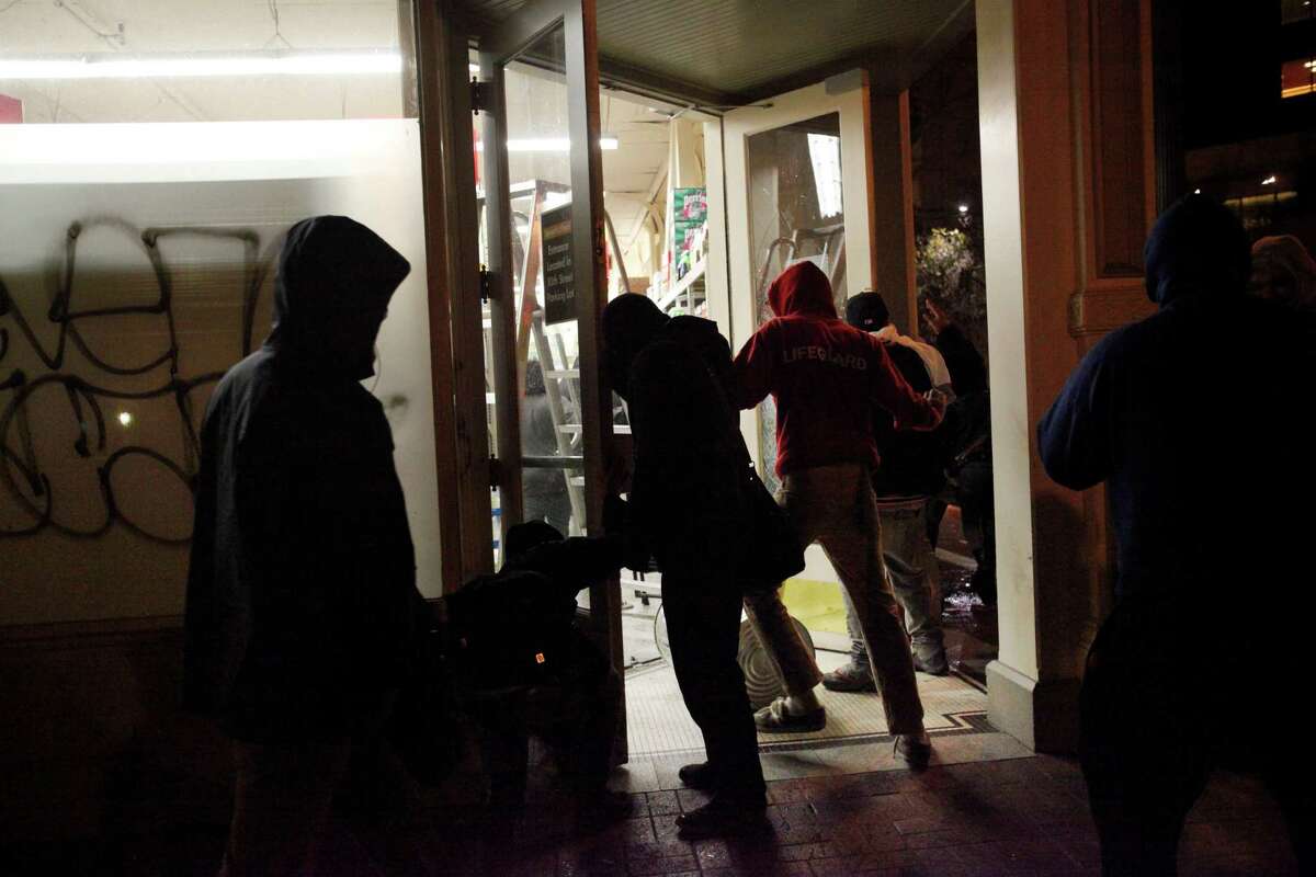 Protesters run into the grocery store Smart and Final to loot it after vandalizing the front and breaking the windows during a protest against the grand jury's decision not to indict the white police officer who fatally shot an unarmed black teenager months ago in Ferguson Nov. 24, 2014 in Oakland, Calif.