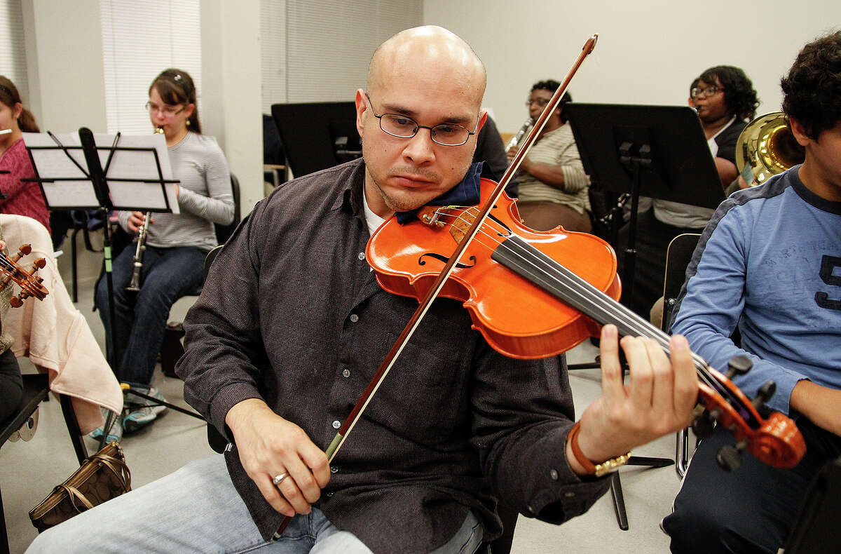 Darren Garza plays the violin at the rehearsal.