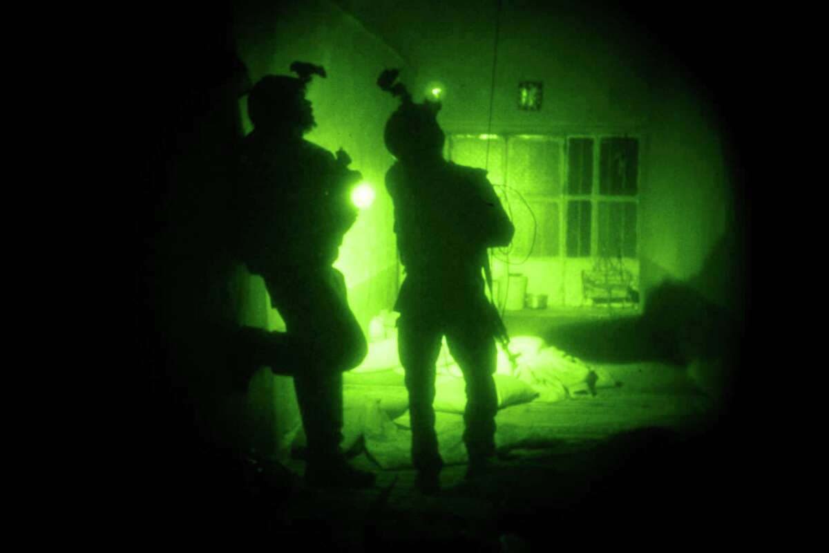 FILE - In this Oct. 28, 2009 file photo taken with a night vision scope, U.S. Special Operations forces search a home during a joint operation with Afghan National Army soldiers targeting insurgents operating in Afghanistan's Farah province. Afghan President Ashraf Ghani has ordered a top-to-bottom review of the practices of the countryâs defense forces, including discussing a possible resumption of controversial night raids banned by his predecessor, the Associated Press has learned. The move appears aimed at revamping the military for the fight against the Taliban amid new indications that U.S. and international forces will play a greater role than initially envisaged. (AP Photo/Maya Alleruzzo, File)