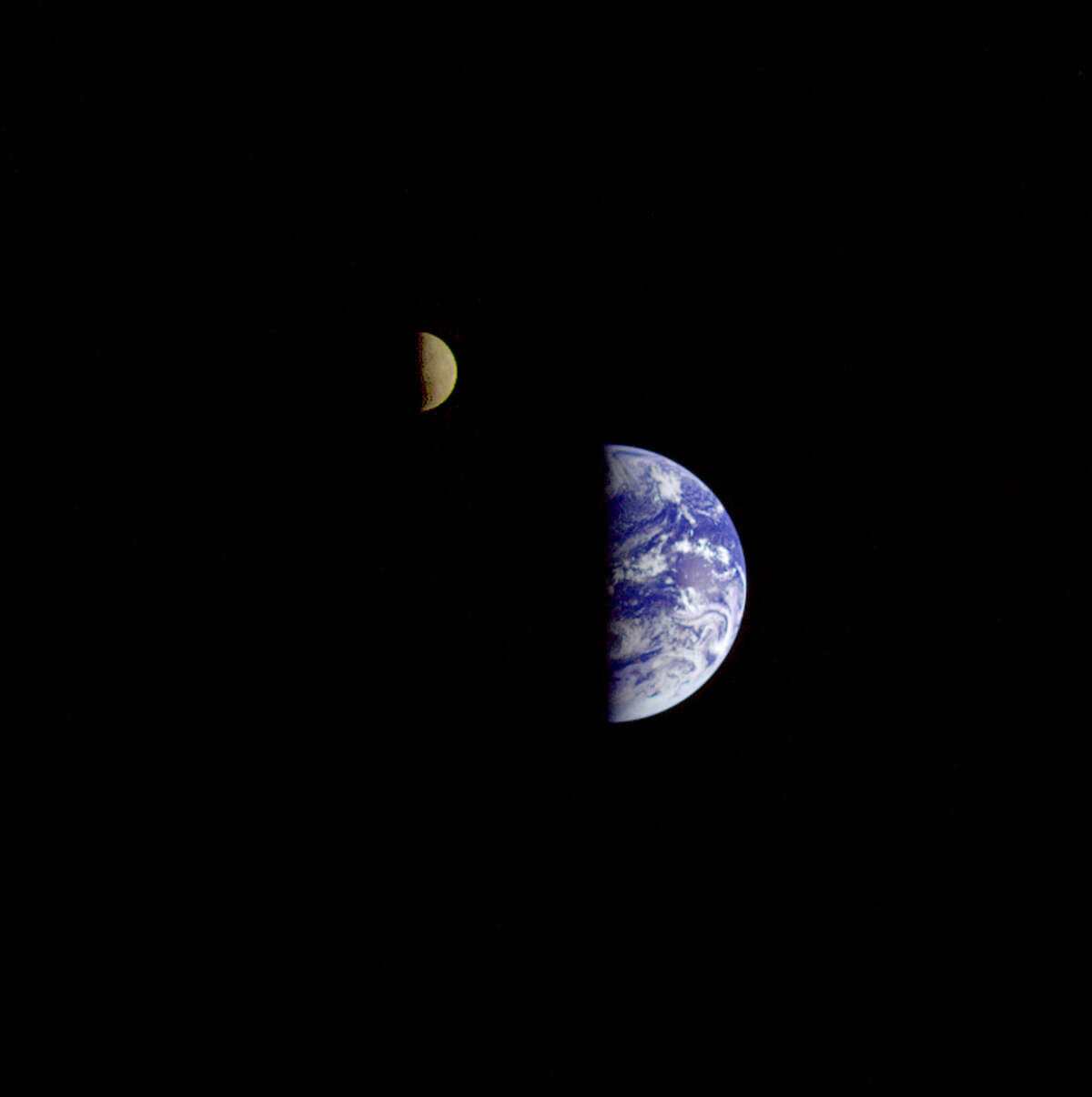 Eight days after its final encounter with the Earth, the Galileo spacecraft looked back and captured this remarkable view of the Earth and Moon. The image was taken from a distance of about 6.2 million km (3.9 million miles). The picture was made with images taken through the violet, red, and 1.0-micron infrared filters. The Moon is in the foreground, moving from left to right. The brightly-colored Earth contrasts strongly with the Moon, which reflects only about one-third as much sunlight as the Earth. Contrast and color have been computer-enhanced for both objects to improve visibility. Antarctica is visible through clouds (bottom). The Moon's far side is seen; the shadowy indentation in the dawn terminator is the south pole Aitken Basin, one of the largest and oldest lunar impact features.
