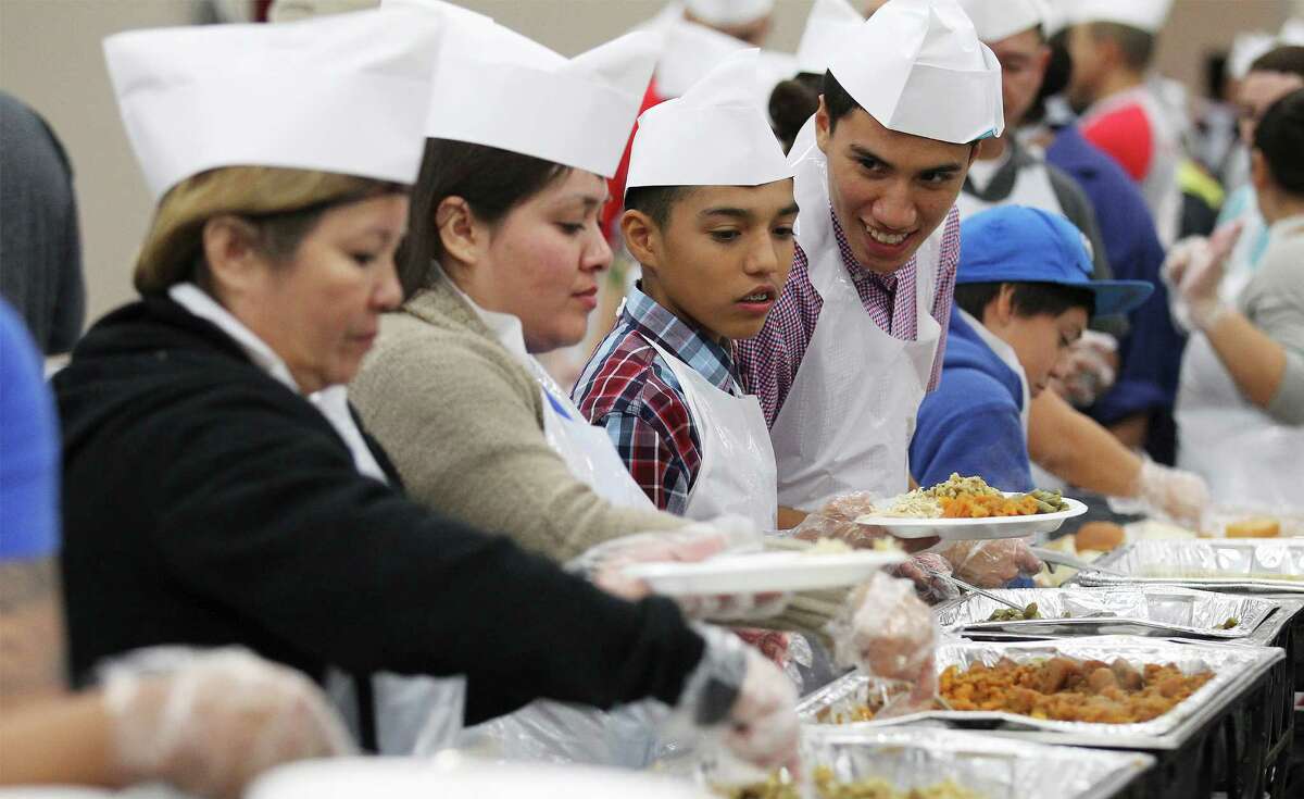 Volunteers of all ages prepare plates of food for guests at the 35th Annual Raul Jimenez Thanksgiving Dinner at the Convention Center in 2014.