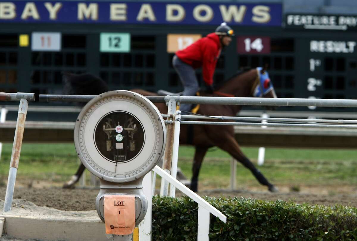 A horse trots on the track behind the scale used to weigh jockeys at the winner's circle at Bay Meadows Race Track in San Mateo, Calif., on Saturday, Aug. 23, 2008.