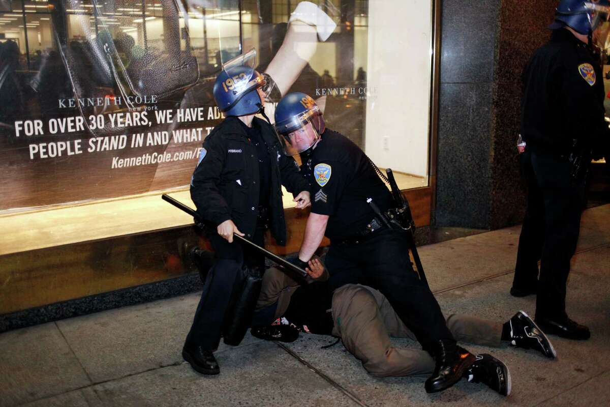 Police detain a man near 5th and Market during a march to call attention to the shooting of Michael Brown and Ferguson, MO on November 28, 2014 in San Francisco, Calif.