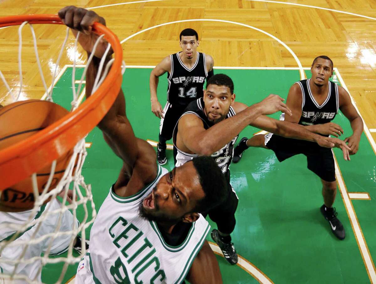 Boston Celtics' Jeff Green dunks on San Antonio Spurs' Tim Duncan during the first half of an NBA basketball game in Boston, Sunday, Nov. 30, 2014. San Antonio won 111-89.