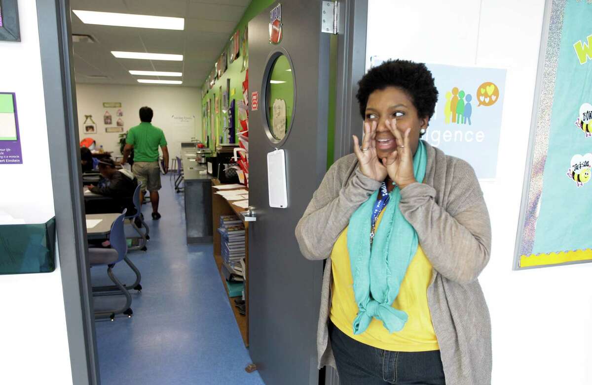 Teacher Brandee Davis gives a countdown to students still in the hall as they change classrooms at KIPPNortheast.﻿