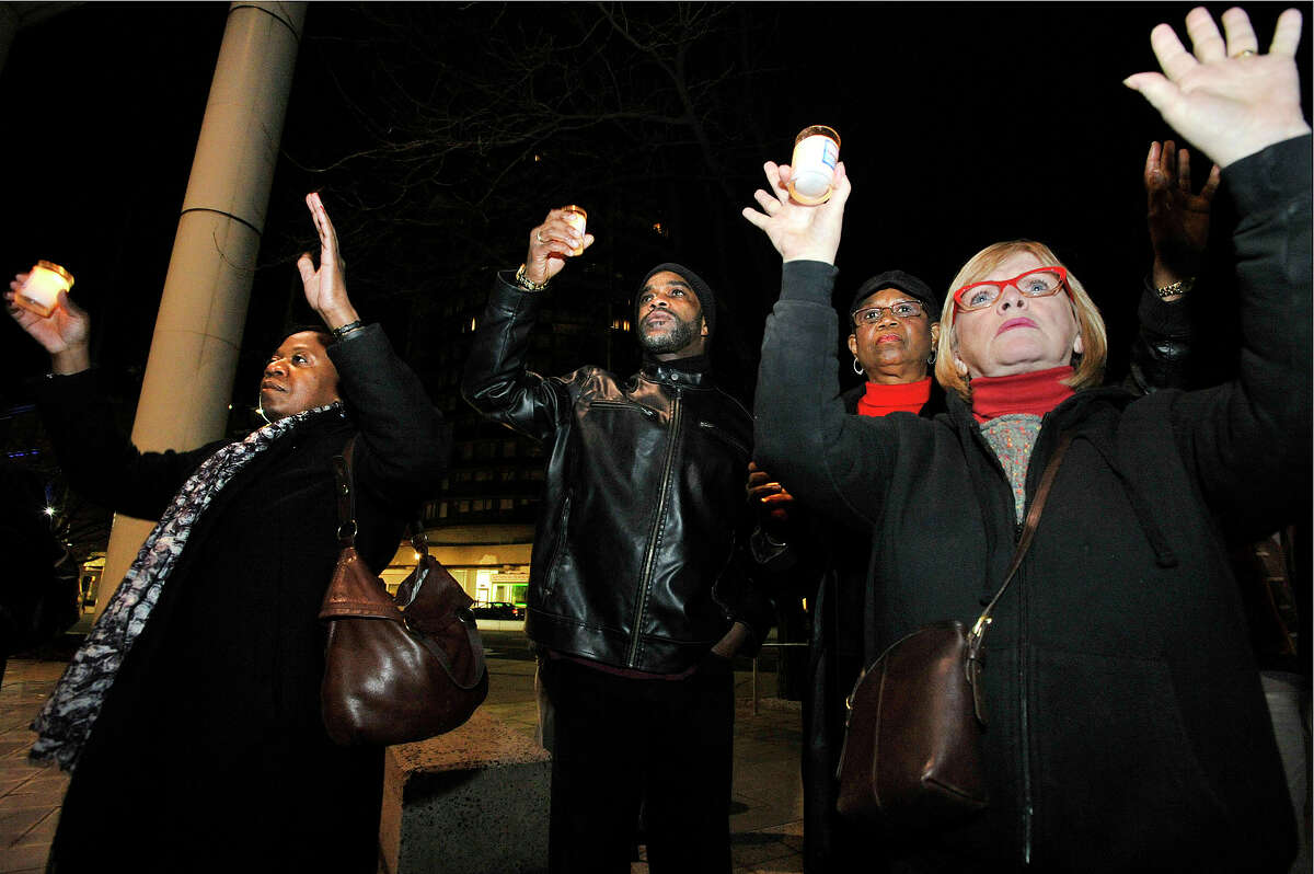 The crowd joins in unison "Hands up, don't shoot" from left: Gina Wynn, Scotty Schmidt, Ann Drakes and Bertilla Baker Thompson during the NAACP rally at the Stamford Government Center in Stamford, Conn., on Sunday, Nov. 30, 2014. The rally was in response to the St. Louis grand jury failing to indict Ferguson Police Officer Darren Wilson in the shooting death of Michael Brown Jr.