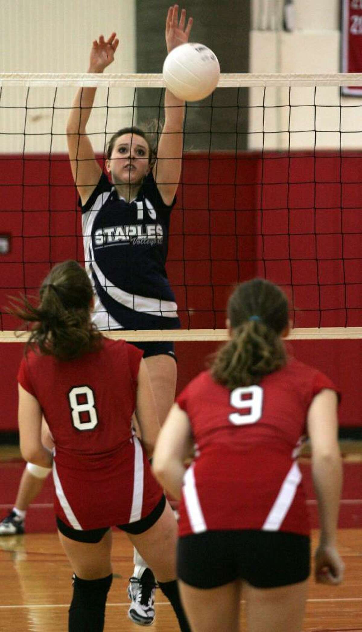 David Ames/for the WESTPORT NEWS Staples Maddy Kalb goes up for the block against Greenwich's Kelsey Goodwin and Kate Centofanti during Saturday mornings Class LL Quarterfinal at Greenwich High School.