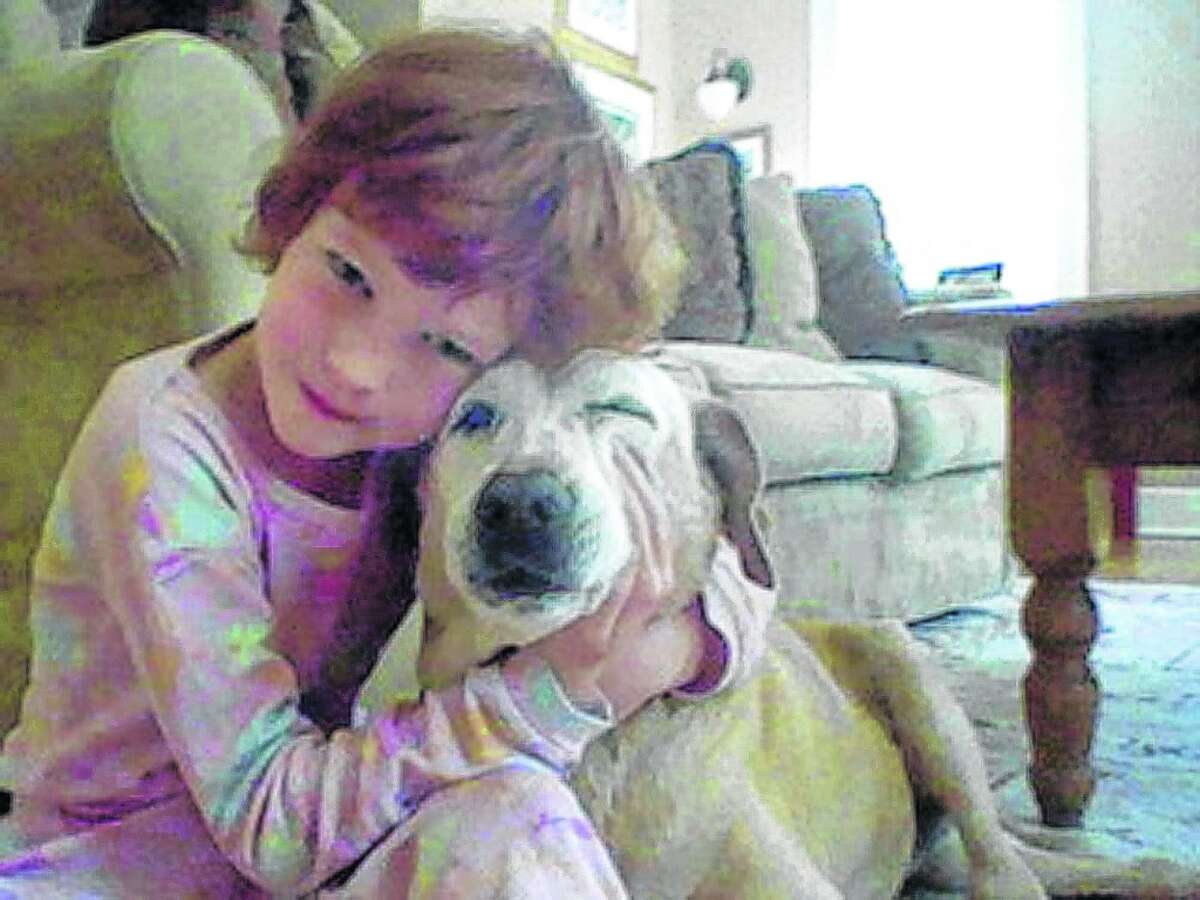 In this April 2012 photo provided by Jenny Hubbard, her daughter Catherine Hubbard hugs their dog Sammy at their home in Newtown, Conn. Despite her tragic death in the mass shooting at Sandy Hook Elementary School on Dec. 14, 2012.