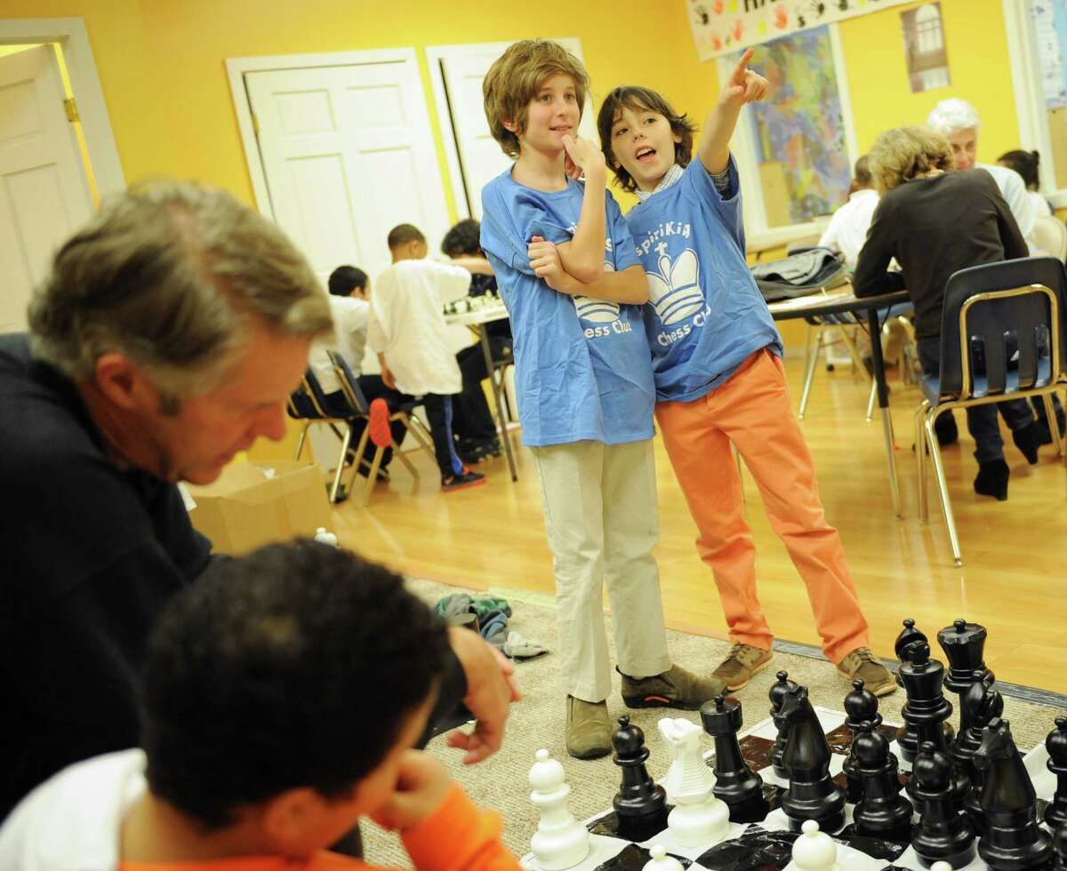 Brunswick School fifth graders Lucas Korn, left, and Max Konzerowsky watch students play chess at the InspiraKing Chess Club at the Inspirica children's shelter in Stamford, Conn. Monday, Dec. 1, 2014. Korn and Konzerowsky started the club to share their love of chess with children at the shelter while helping them build strategic and creative thinking skills.