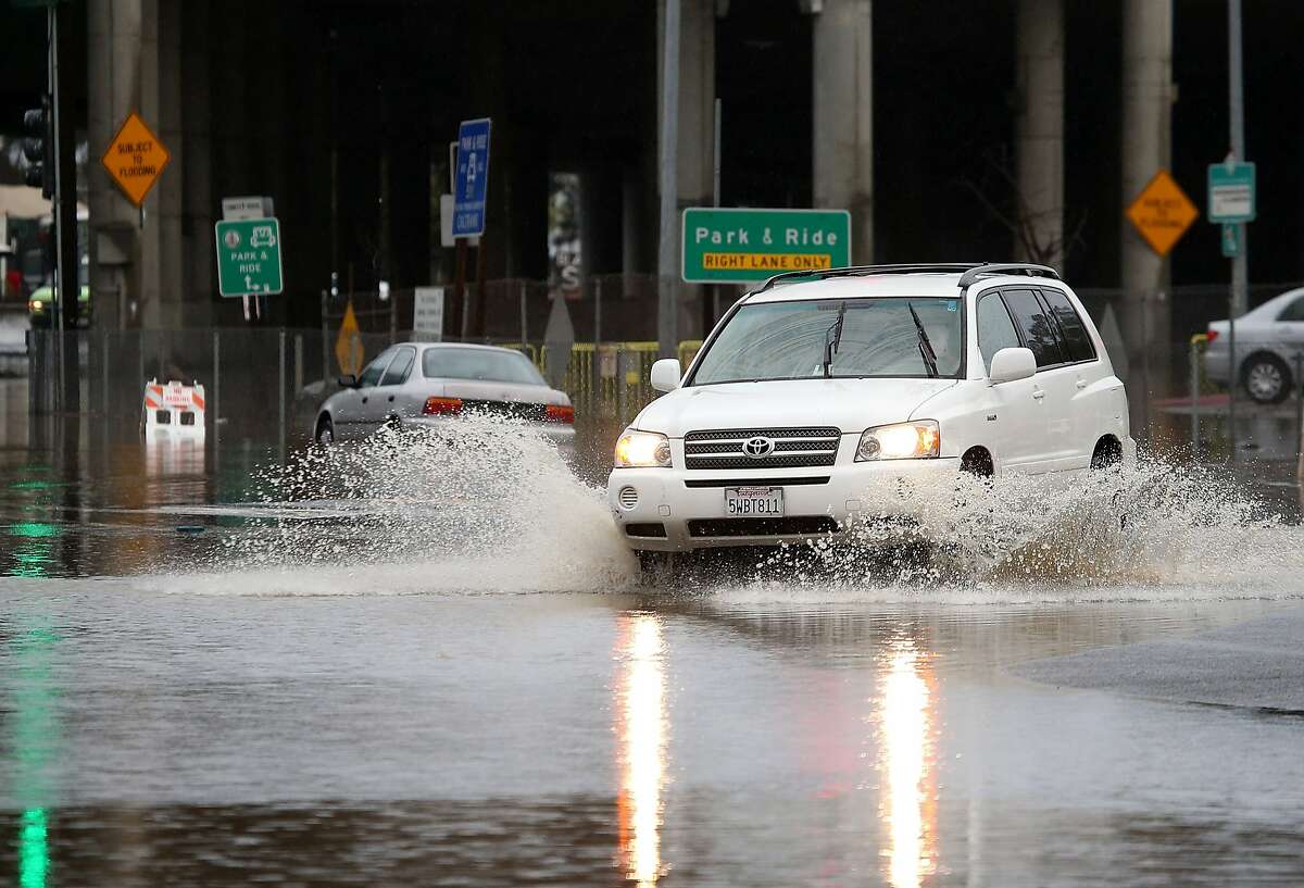 MILL VALLEY, CA - DECEMBER 03: A motorist drives through a flooded intersection on December 3, 2014 in Mill Valley, California. The San Francisco Bay Area is being hit with its first major storm of the year that is bringing heavy rain, lightning and hail to the region. The heavy overnight rain has caused flooding which has blocked several roadways and caused severe traffic backups. (Photo by Justin Sullivan/Getty Images)