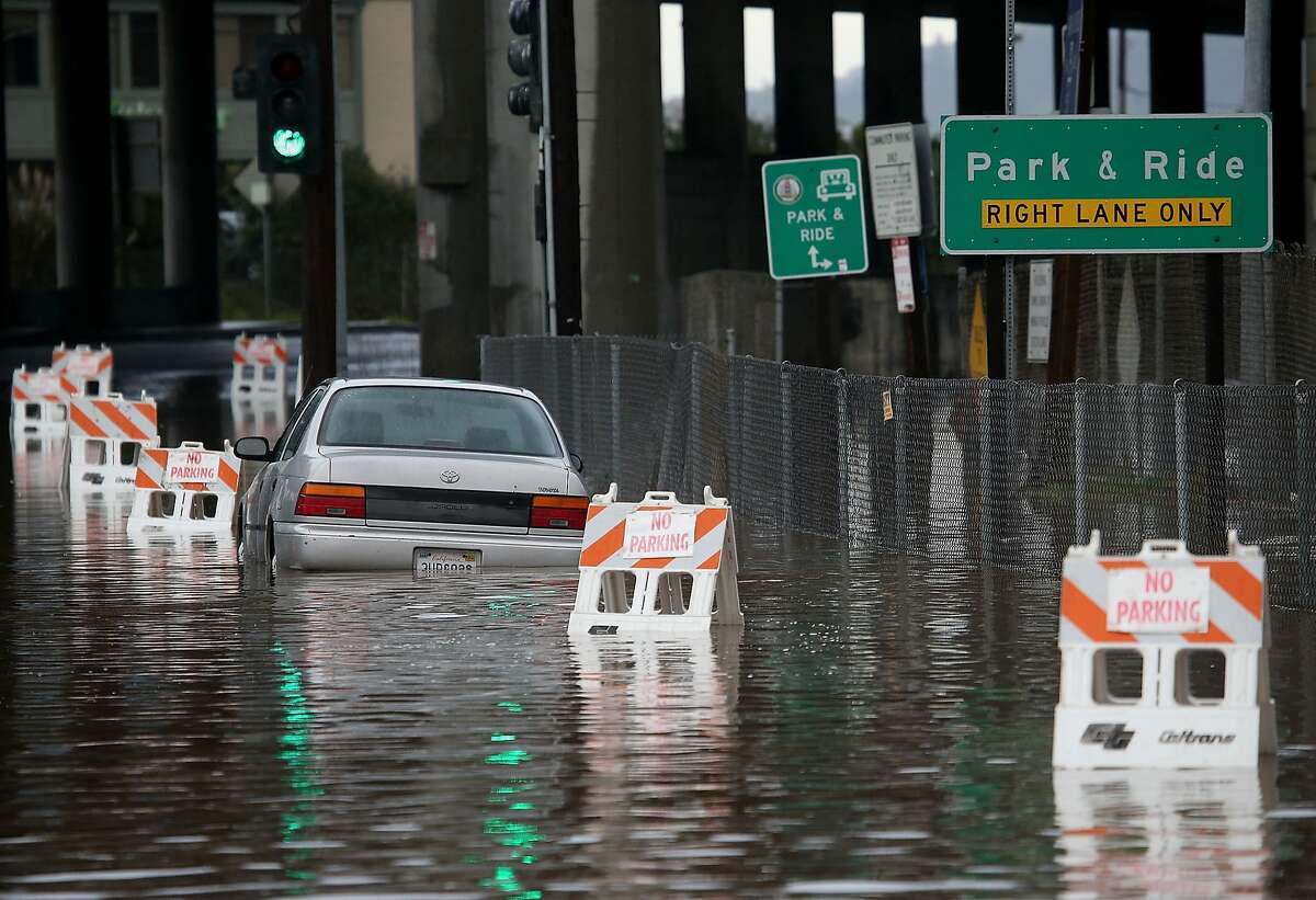 MILL VALLEY, CA - DECEMBER 03: A car sits partially submerged in water on a flooded section of roadway on December 3, 2014 in Mill Valley, California. The San Francisco Bay Area is being hit with its first major storm of the year that is bringing heavy rain, lightning and hail to the region. The heavy overnight rain has caused flooding which has blocked several roadways and caused severe traffic backups. (Photo by Justin Sullivan/Getty Images)