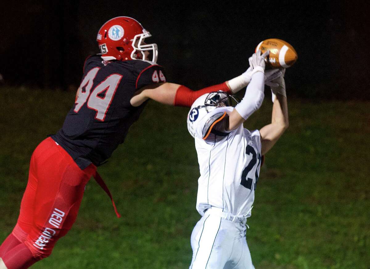 New Canaan's Zach Allen and Wilton's Patrick Ryan reach for a pass in a failed two-point conversion attempt during Friday's football game at New Canaan High School on November 7, 2014.
