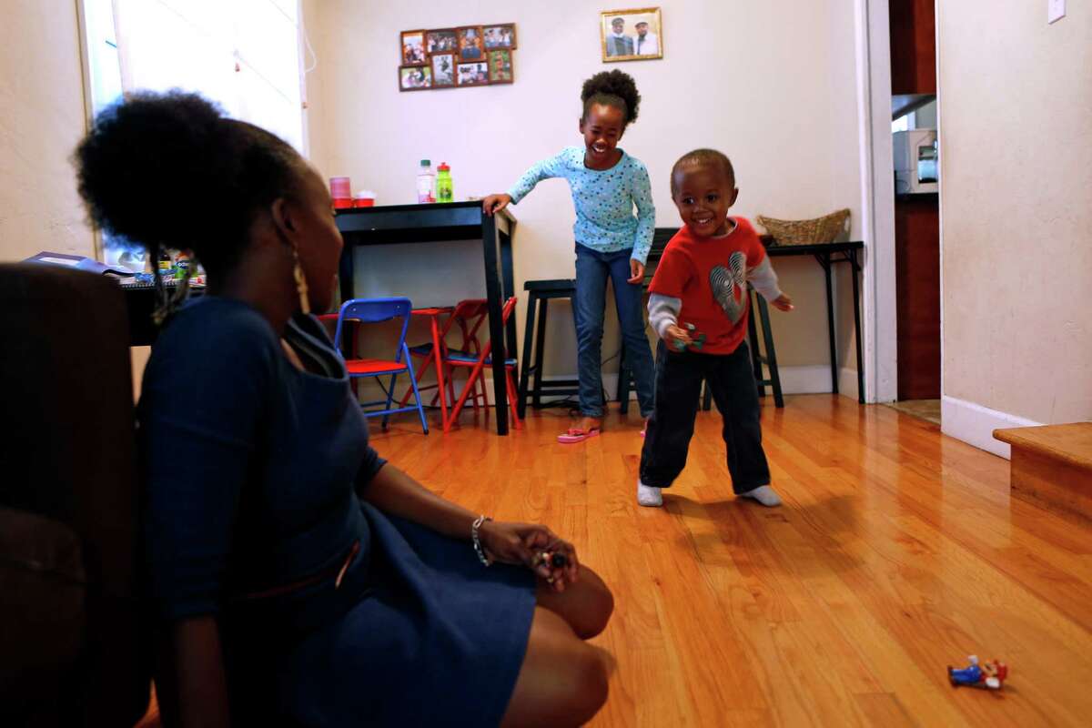 Kehinde Kujichagulia-Setu watches her son, Cameron, 3, dance as daughter, Xion, 10, laughs at the performance at their home in Oakland, Calif., on Wednesday, November 26, 2014.