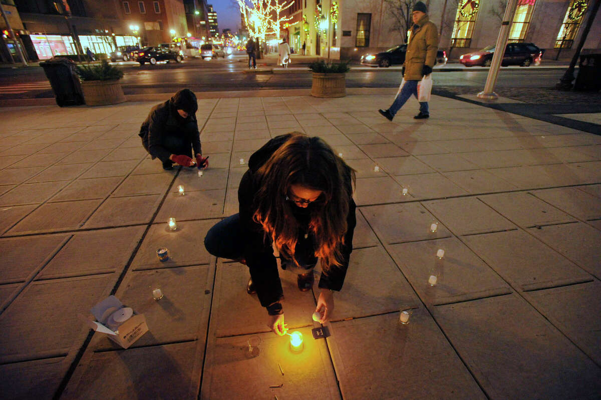 Dana Horowitz, center, and Wendy Skratt light candles in a circle before The ENOUGH Campaign's Vigil of Hope helping to raise awareness of the victims lost to gun violence throughout the United States in front of the Ferguson Library in Stamford, Conn., on Thursday, Dec. 12, 2013. This year's event will be 5:30-7 p.m Thursday, Dec. 11 in front of the library.