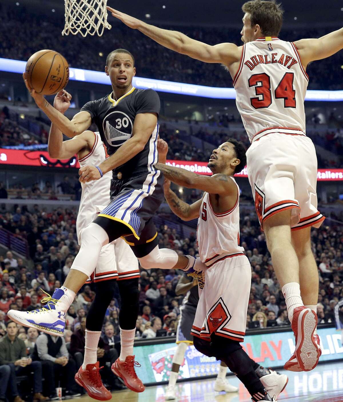 Golden State Warriors guard Stephen Curry (30) looks to pass against Chicago Bulls center/forward Joakim Noah (13), guard Derrick Rose (1) and guard/forward Mike Dunleavy (34) during the first half of an NBA basketball game in Chicago on Saturday, Dec. 6, 2014.