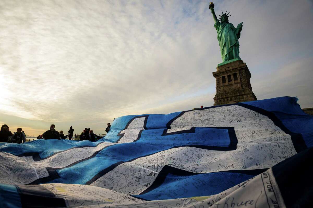 Jan. 31 — Fans and Space Needle personnel work to unfurl a 25-foot by 35-foot 12th Man flag under the Statue of Liberty in honor of the Seahawks' making it to the Super Bowl on Liberty Island in New York. The flag journeyed from Seattle to Manhattan on a cross-country trip. The flag carried the signatures and messages of thousands of fans hoping for a Seahawks win.