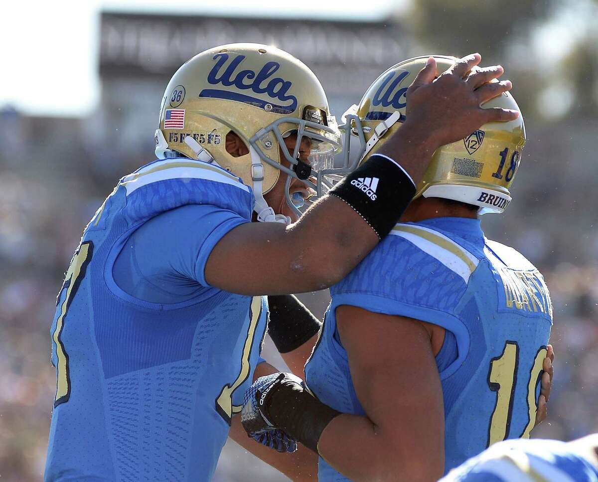 PASADENA, CA - NOVEMBER 28: Brett Hundley #17 of the UCLA Bruins celebrates his touchdown pass to Thomas Duarte #18 to take a 7-0 lead over the Stanford Cardinal at Rose Bowl on November 28, 2014 in Pasadena, California. (Photo by Harry How/Getty Images)