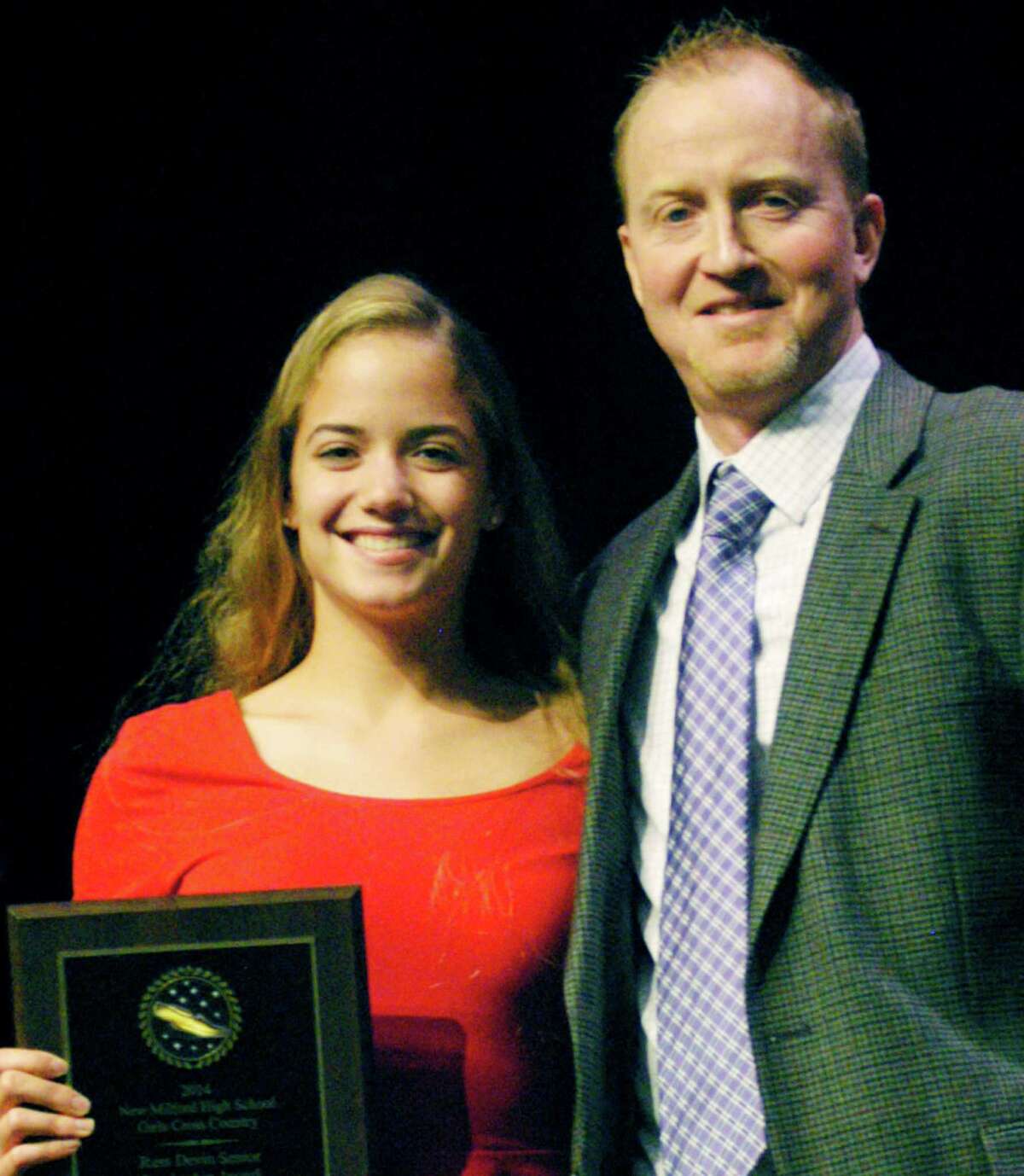 Nicole McCarthy is presented her team's Russell Devin Award by Green Wave girls' cross country coach Giles Vaughan during New Milford High School's annual fall sports awards ceremony, Dec. 1, 2014. The award is given each year to a standout senior in memory of Devin, the legendary Green Wave cross country and track coach.