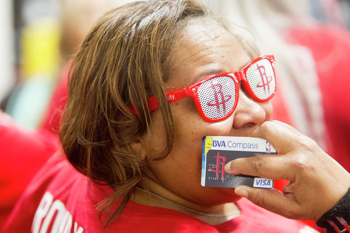 Myrna Davis keeps her BBVA Compass bank card close before a Houston Rockets game this season at the Toyota Center. It's part of the way the pro basketball fan shows her team spirit.﻿