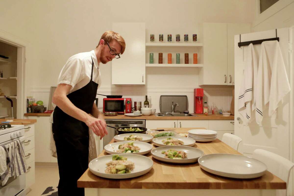 Chef Colin Mealey prepares dinner in the home of Ian Ferguson, one of Kitchit’s founders. It costs $39 per person for a starter, entree and dessert.