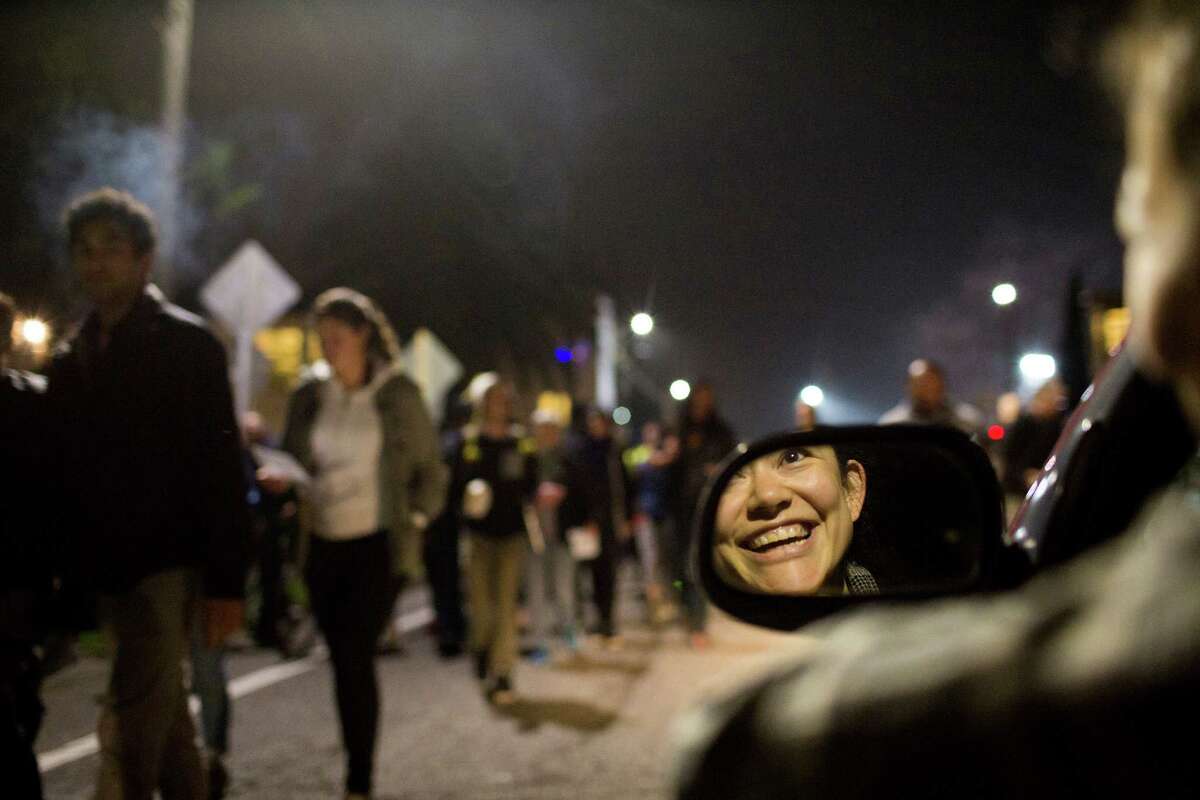Sara Spriggs, 30, of Oakland, cheers on protesters as they march in Berkeley to demonstrate against grand jury decisions in Ferguson and New York, in Berkeley, Calif., on Tuesday, December 9, 2014.