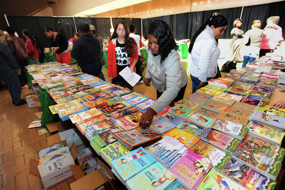 Adrienne Lowe sifts through several donated books during toy distribution for the Empty Stocking fund on Tuesday. Around $6,000 worth of books were donated by Mike Fuljenz. Photo taken Tuesday, December 9, 2014 Guiseppe Barranco/The Enterprise