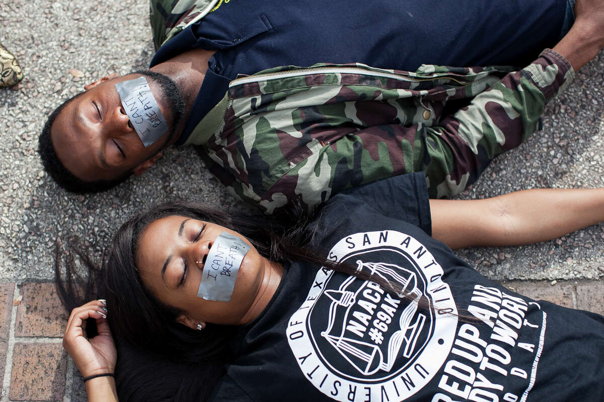 UTSA senior Ashely Andrews and junior Chad Davis lay Wednesday Dec. 10, 2014 during a "Die-in" in honor of Michael Brown and Eric Garner, where they laid for 15 and half minutes at Sombrilla Plaza. The event was sponsored by the UTSA NAACP chapter in an effort to shed light on police brutality and injustice, with about 80 people participating.
