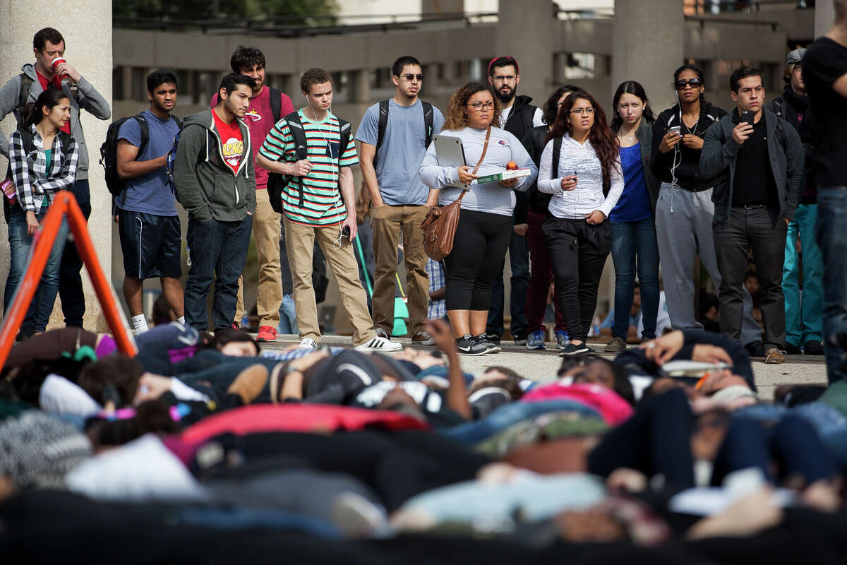 A crowd watches as about eighty UTSA students gathered at Sombrilla Plaza Wednesday Dec. 10, 2014 for a "Die-in" in honor of Michael Brown and Eric Garner, where they laid for 15 and half minutes. The event was sponsored by the UTSA NAACP chapter in an effort to shed light on police brutality and injustice.