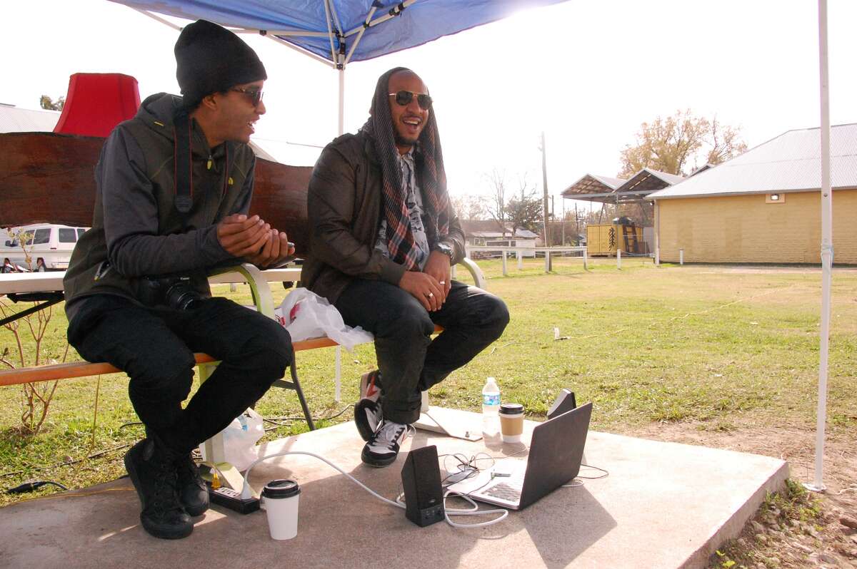 The Black Guys, Robert Hodge and Phillip Pyle II, sit by the bus stop near their studio in the Third Ward.