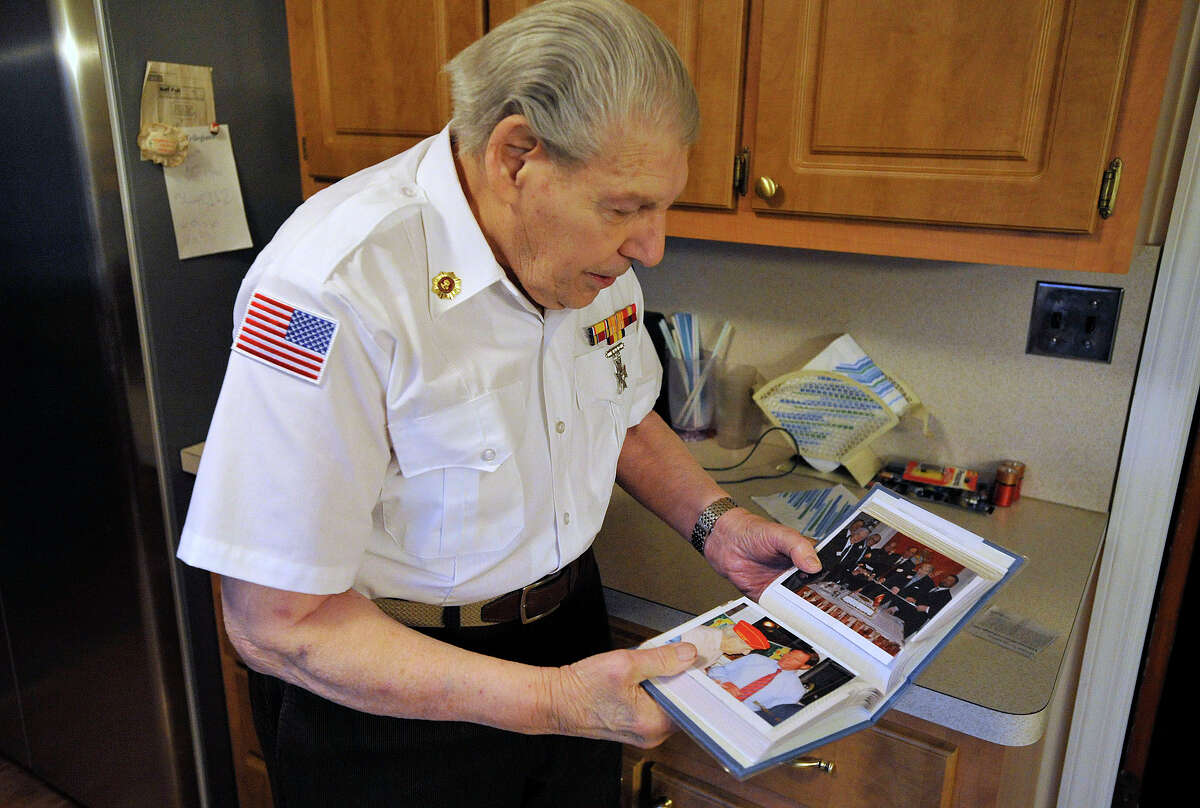 John Geas, 91, looks over old photos at his home in Stamford, Conn., on Monday, Dec. 8, 2014. Geas was a Master Sergeant in the US Marine Corps' 4th Marine Division during World War II and stormed the beaches of Guadalcanal, Saipan, Tinian and Iwo Jima.