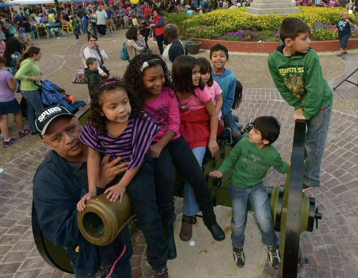 Michael Bueno holds his granddaughter, Natalie Mauricio, 6, as they and others play on a cannon at the "Let it Snow: A Holiday Celebration" event by Centro San Antonio and the City of San Antonio at Travis Park on Saturday, Dec. 13, 2014. Free hot chocolate and apple cider were served and volunteers from the Davis-Scott Family YMCA, San Antonio Public Library Teen Services and the San Antonio Childrenâ€™s Museum were on hand to coordinate arts and crafts activities.