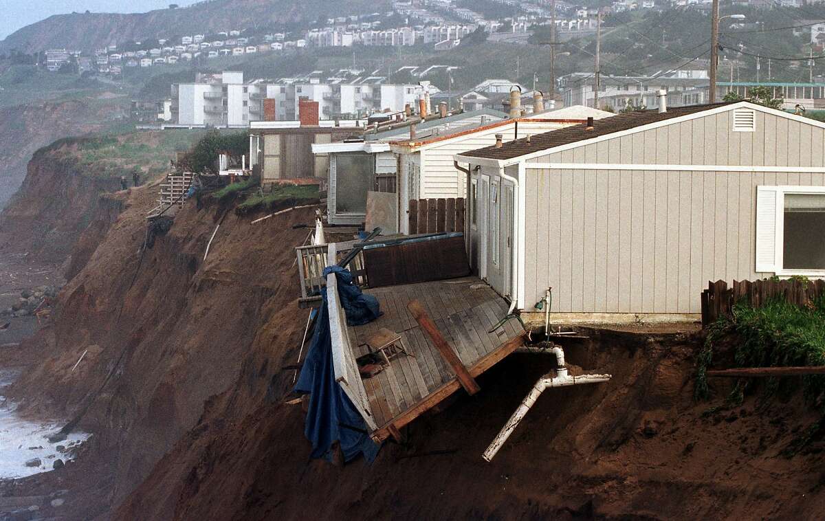 Homes are seen perched precariously on a hillside overlooking the Pacific Ocean Wednesday, Feb. 25, 1998, in Pacifica, Calif. The cliffside has been weakened by El Nino driven high surf and incessant rains over the past months, causing the hill to slide and threaten several homes. (AP Photo/George Nikitin)